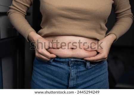 Fat woman upset because excess weight stomach. He touches fat belly wants lose weight. Diet, Lifestyle, Eating Disorder, Fast Food, Carbohydrate Intake, Overweight. Traces of clothing on the body