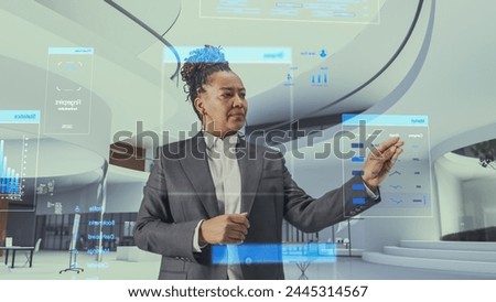 Futuristic Black Business Leader Businesswoman Standing in Virtual Space, Gesturing with an Augmented Reality Hologram Analysing Big Data, Financial Reports, Stock Market Statistics, Infographics
