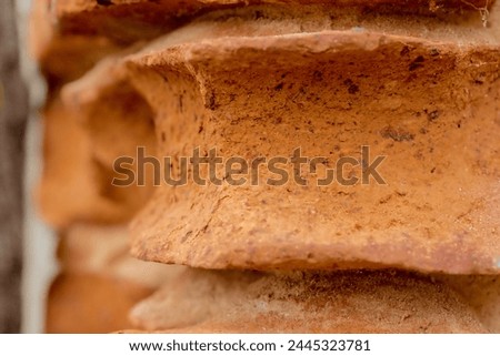 A wall made of old, heavily eroded red bricks. A heavily damaged brick wall made of bricks with extremely strange shapes given by time - and rain, wind, frost, etc.. ) ....  Royalty-Free Stock Photo #2445323781