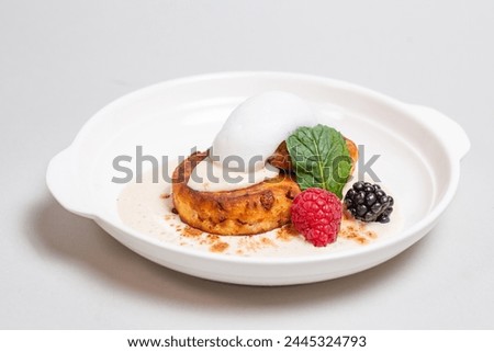 Gourmet cottage cheese pancakes with berries on white plate on white background. Delicious breakfast food.