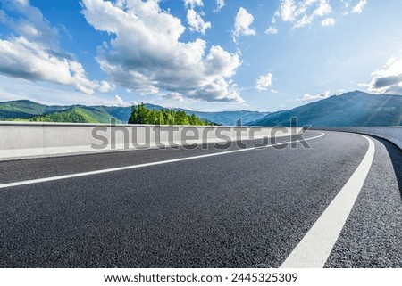 Asphalt highway road and green mountains with sky clouds background