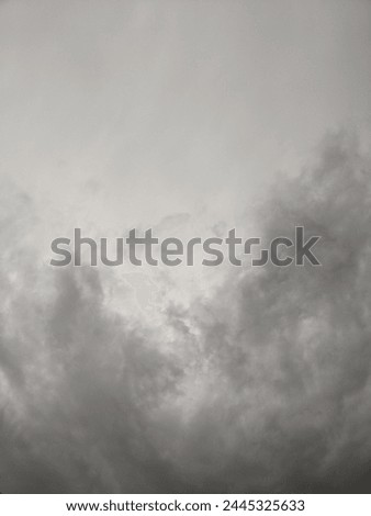 A pict of post-rain atmosphere, with brooding clouds dissipating into a dusky sky. Sparse rays of light pierce through the lingering darkness,and evoking a sense of tranquil beauty. Royalty-Free Stock Photo #2445325633
