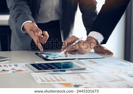 Business partnership coworkers using a tablet to chart company financial statements report and profits work progress and planning in office room. Royalty-Free Stock Photo #2445331673