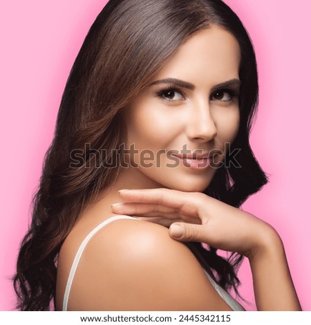 Portrait of pleasant smiling young beautiful woman brunette girl wear white casual clothing, isolated over against rose pink color wall background. Square composition studio image. Royalty-Free Stock Photo #2445342115
