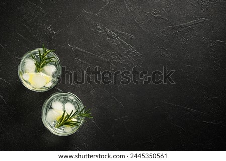 Gin tonic, traditional cocktail on black background. Top view with space for design.