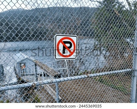 Photo of a fence and no parking sign