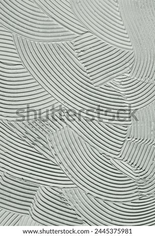 Cement wall cementitious adhesive applied to the floor.Modern gray background with curved lines Royalty-Free Stock Photo #2445375981