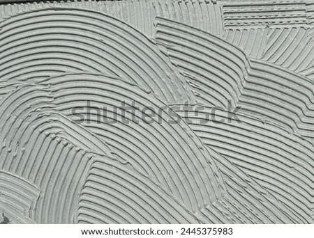 Cement wall cementitious adhesive applied to the floor.Modern gray background with curved lines Royalty-Free Stock Photo #2445375983