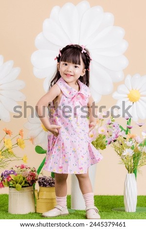 Portrait long-haired girl in a pastel pink dress Posing for a photo in the studio has an orange background and props, wicker baskets and flowers