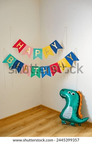 colorful birthday garland on the wall with dragon balloon