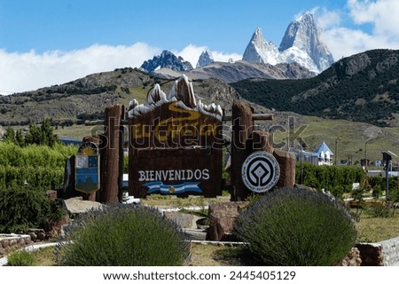 welcome sign to El Chaltén, with Fitz Roy mount in the background. Sign Translation: El Chalten. National Capital of Trekking. Welcome