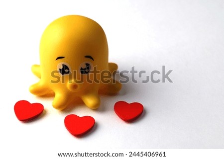 Octopus children bath toy.Childrens rubber toy octopus on white background side view.image of rubber toy white background .Octopus toy and red hearts