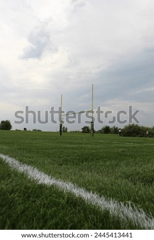 This is an image of a goalpost on a football field with a beautiful grass foreground and scenic background Royalty-Free Stock Photo #2445413441