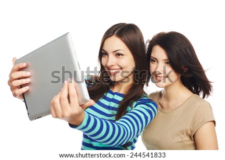 Two girls friends taking selfie with digital tablet, isolated on white background