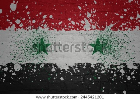 colorful painted big national flag of syria on a massive old brick wall