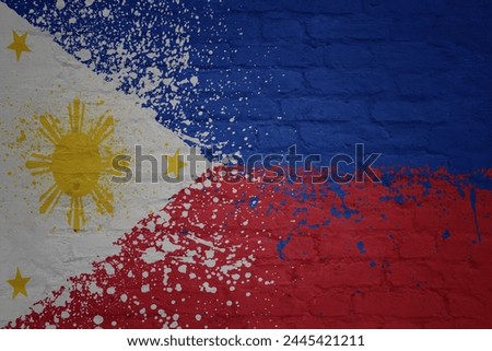colorful painted big national flag of philippines on a massive old brick wall