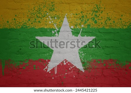 colorful painted big national flag of myanmar on a massive old brick wall