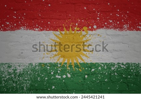 colorful painted big national flag of kurdistan on a massive old brick wall