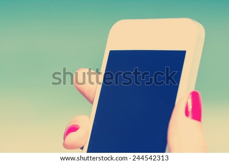 Retro Photo Of Young Girl Hand Holding Mobile Phone Similar To iPhone