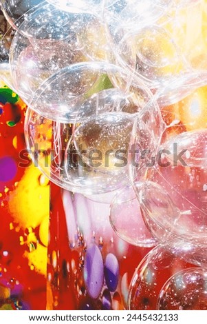 A large number of transparent plastic bubbles floating in the air. The balls are in a colorful red-yellow room, creating a visually attractive and playful atmosphere Royalty-Free Stock Photo #2445432133
