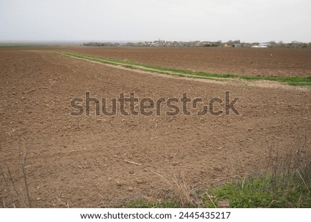 A tractor-plowed field in Chalma, Serbia. Agribusiness. Agricultural land. Fertile black soil. Row of furrows in a plowed field prepared for planting crops in the spring. Horizontal perspective view