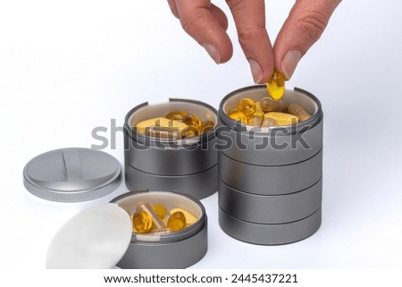 Pills in a pill pot, daily dose of vitamin pills and suppliments in a container. Royalty-Free Stock Photo #2445437221