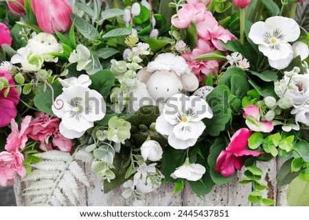 Adorable spring decoration made of artificial flowers. Easter traditional motifs. 
