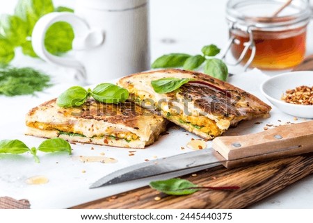 Naan bread breakfast sandwiches with basil and honey, ready for eating. Royalty-Free Stock Photo #2445440375