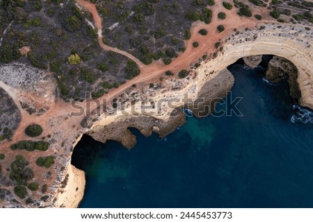Portuguese Atlantic coast with cliffs and caves and tourist paths - aerial birdeye drone view