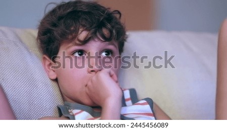 Child watching movie looking at TV screen
