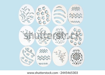 Handmade wooden Easter eggs with patterns on a blue background.