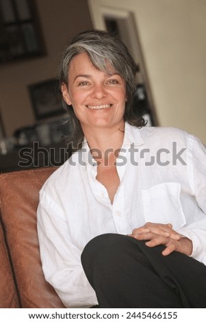 portrait of a smiling mature woman sitting on the couch
