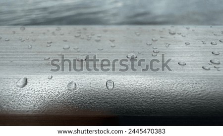 macro water drops photo on the hand rail of the bridge.