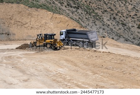 Construction work in the mountains, the tractor is working. stock photo