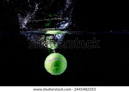 tennis dropping into water and going under water Royalty-Free Stock Photo #2445482353