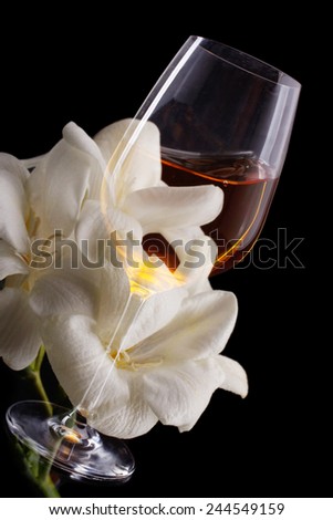 Double exposure of glass of wine over white freesia, a vertical picture