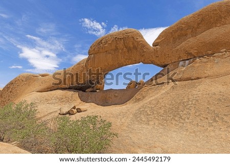 Panoramic picture of the famous stone arch at the Spitzkoppe in Namibia during the day with blue sky in summer