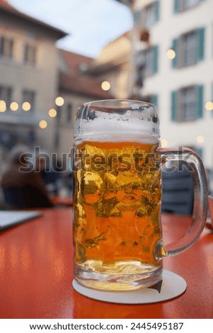 Glass of cold beer on table in cafe outside. Royalty-Free Stock Photo #2445495187