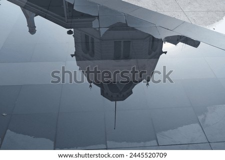 Upside-down reflection of an ornate building on a glossy surface, merging architecture with the art of photographic symmetry