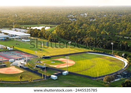 Sports facilities at public school in Florida, USA. American football stadium, tennis court and baseball diamond sport infrastructure