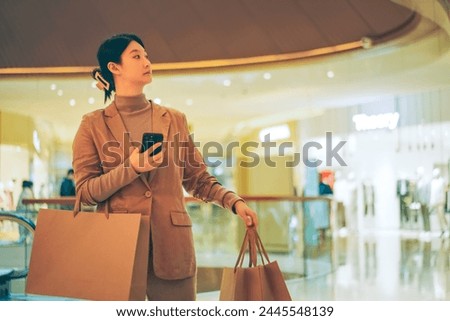 Stylish Shopper with Smartphone in Upscale Mall