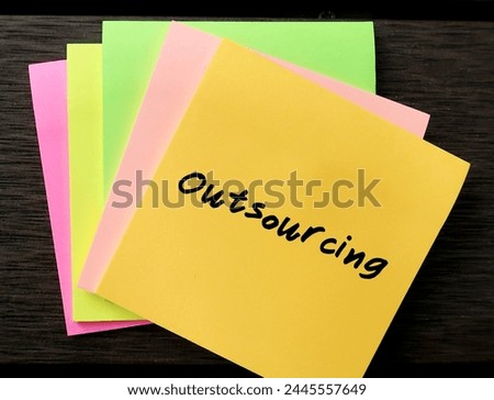 Note paper with word - Outsourcing - practice used by business to reduce costs by transferring portions of work to outside suppliers or outsource Royalty-Free Stock Photo #2445557649