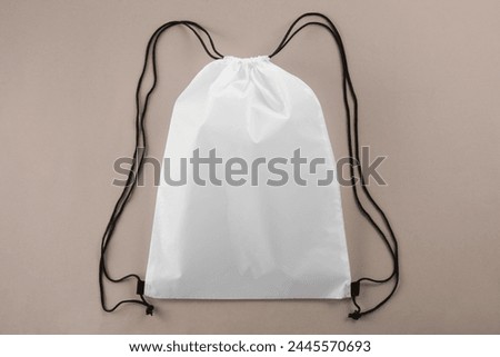 One white drawstring bag on beige background, top view Royalty-Free Stock Photo #2445570693