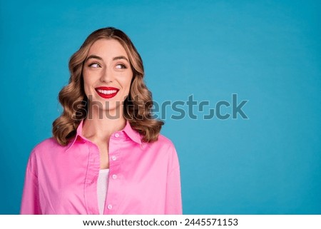 Photo portrait of lovely young lady look empty space dressed stylish pink garment hairdo isolated on blue color background