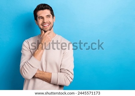 Photo of intelligent guy stylish hairstyle dressed white pullover look empty space think business idea isolated on blue color background