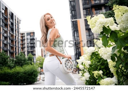 Photo of adorable lovely cute positive girl walking traveling outdoors sunny days at residential complex territory