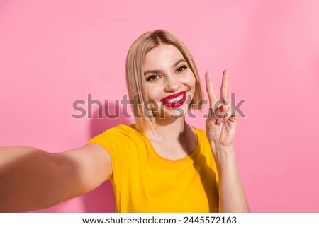 Photo of friendly pretty lady dressed yellow t-shirt showing v-sign tacking selfie isolated pink color background