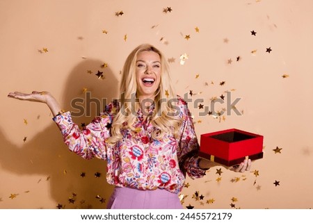 Portrait of pretty lady hold opened giftbox confetti wear shirt isolated on beige color background