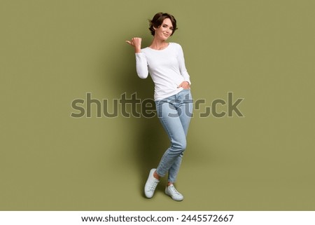 Full size photo of confident promoter girl directing thumb finger empty space ads adv ad isolated khaki green color background