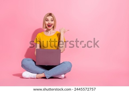 Full length photo of dreamy impressed lady dressed yellow t-shirt working device showing thumb empty space isolated pink color background